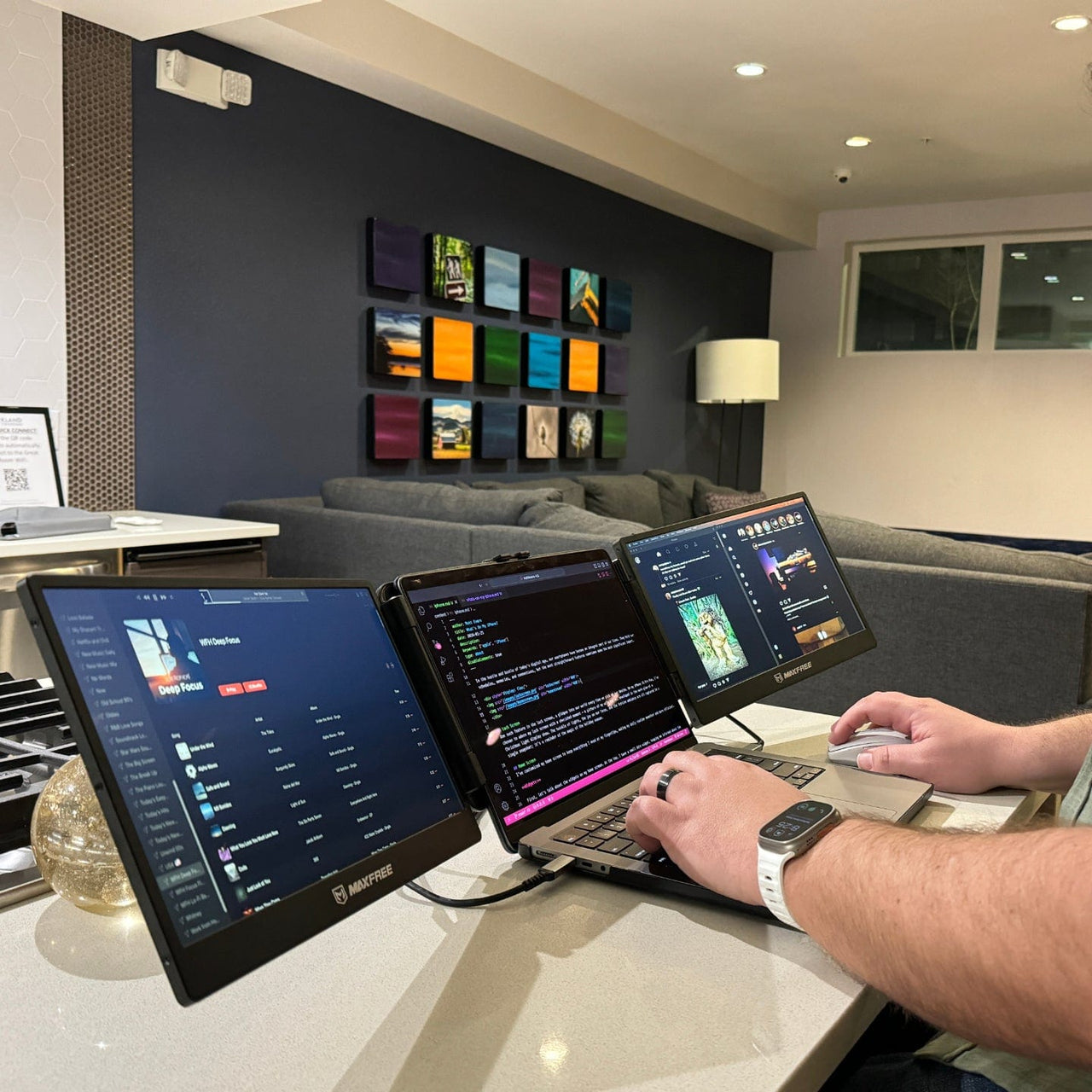 Triple screen portable monitor connected to a laptop displaying coding, dashboards, and applications across three screens for improved workflow efficiency