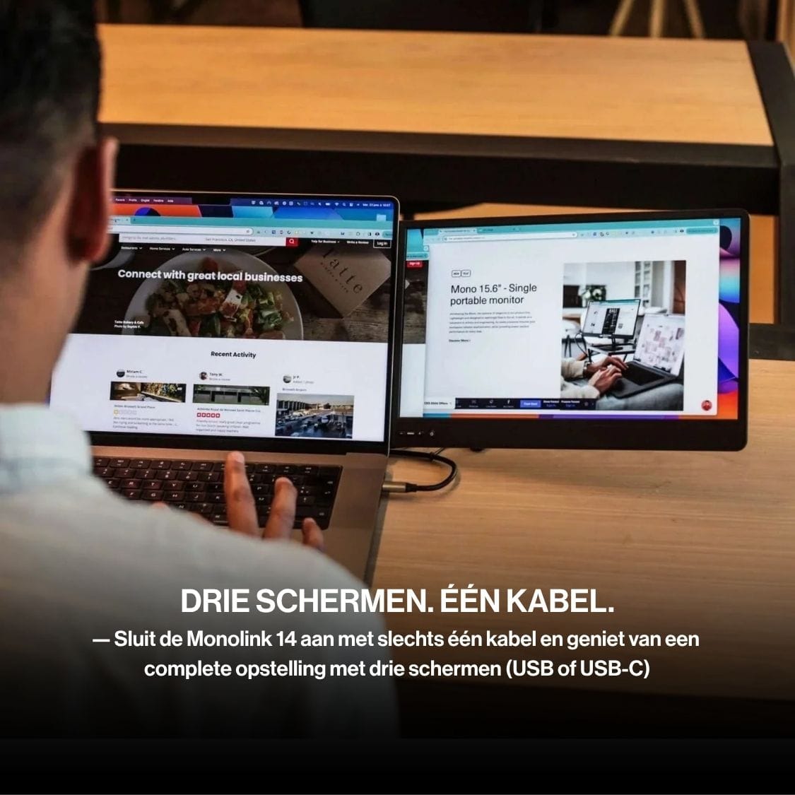 Person using a laptop with a portable monitor and two side displays, creating a three-screen workspace connected with a single cable.