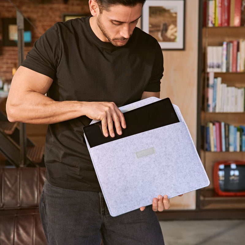 Person sliding a portable monitor into a soft felt sleeve, emphasizing the lightweight, travel-friendly design and easy storage for work on the go.