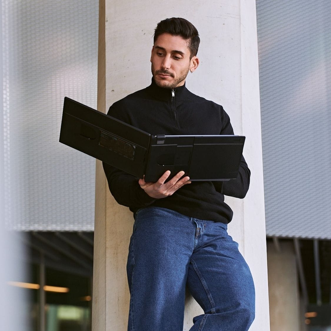 Person holding an open portable monitor and laptop screen extender, showing the lightweight foldable design for mobile working.