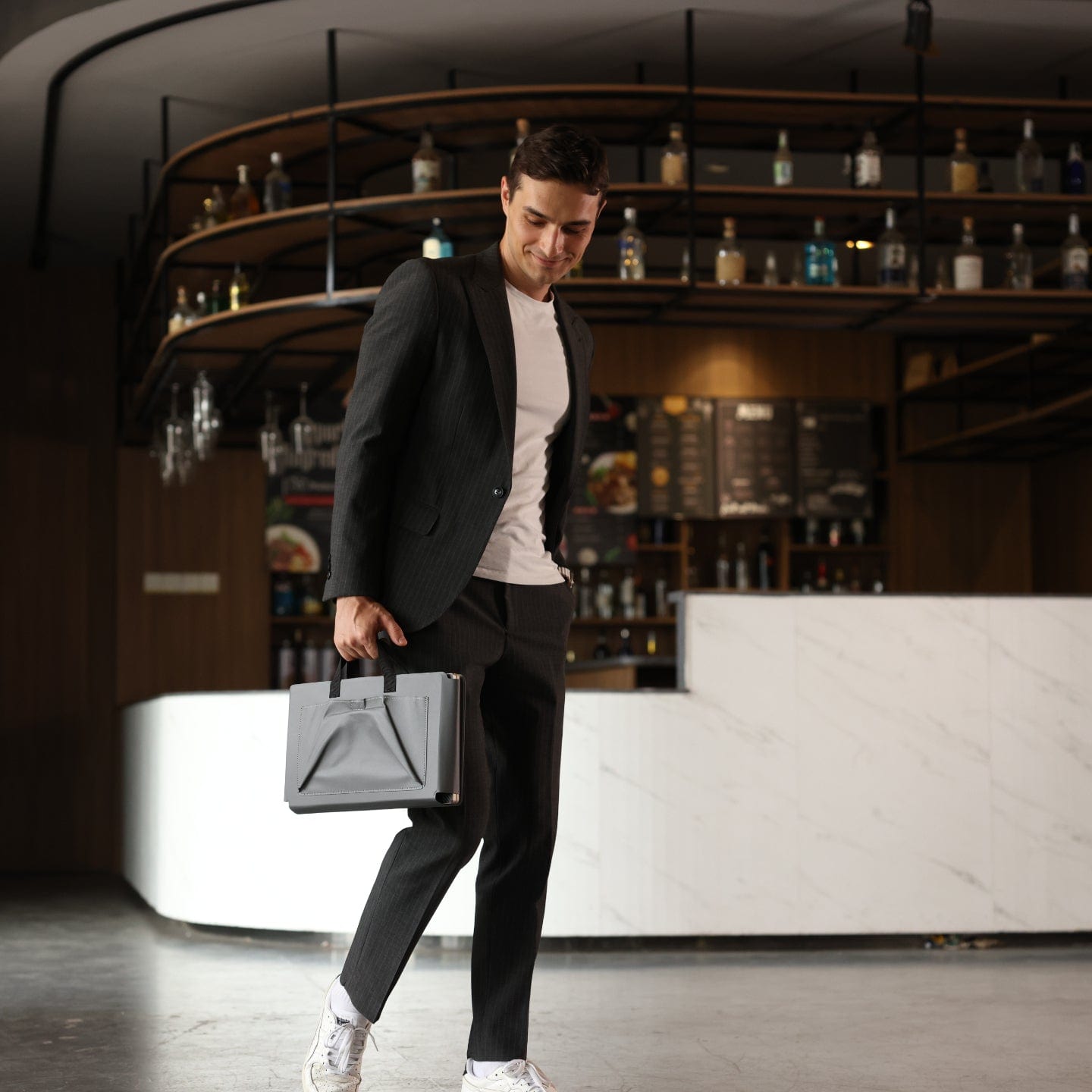 Man carrying a slim and lightweight portable monitor system in a compact case, highlighting easy portability for work on the go