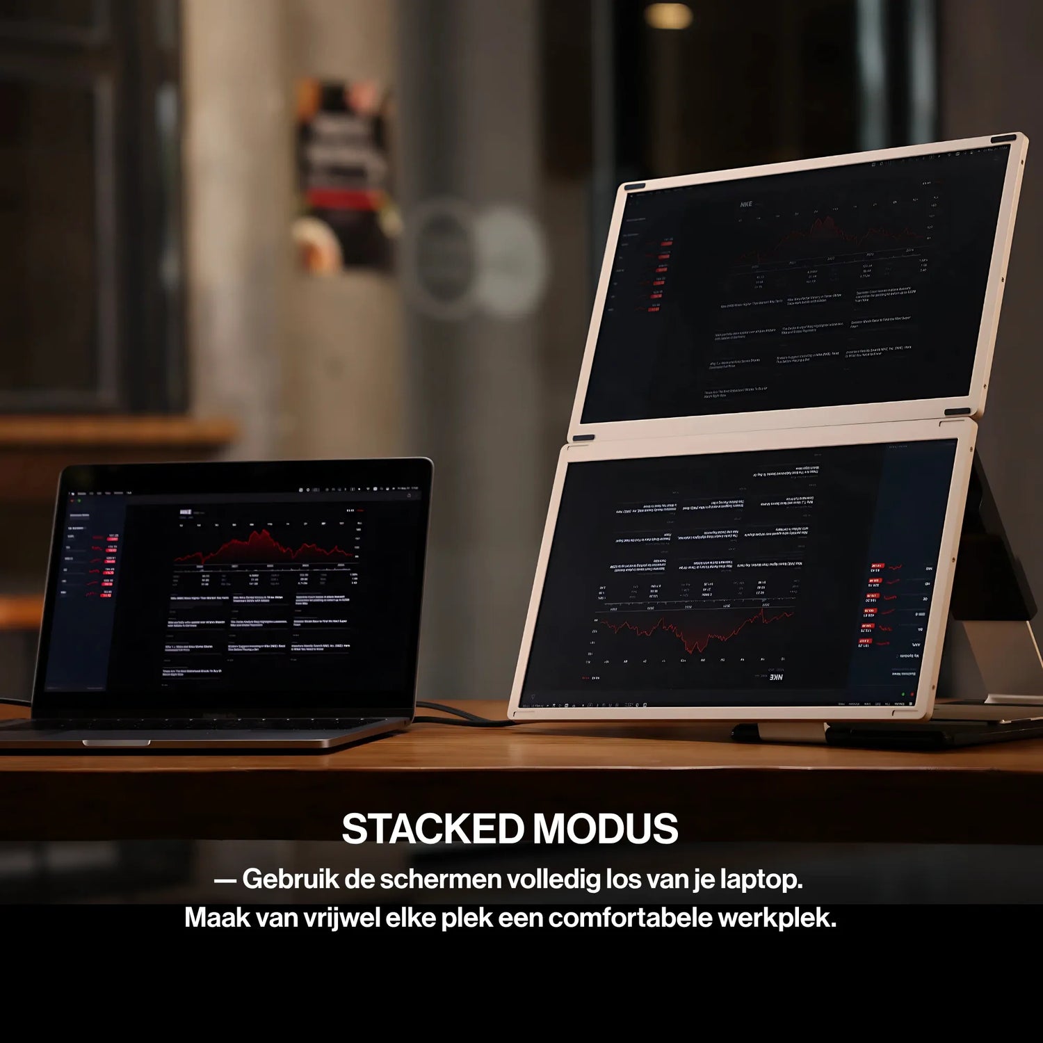 Portable monitor dual-screen workstation with two stacked displays beside a laptop, showing dashboards, graphs, and financial data.