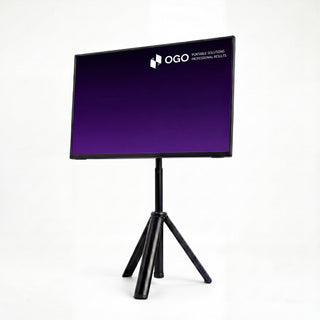 Angled front view of an OGO portable monitor mounted on a black tripod stand, displaying a purple screen for a clean elevated workstation setup